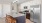 a kitchen with white cabinets an island a fridge and a stovetop