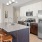 a kitchen with white cabinets an island a fridge and a stovetop