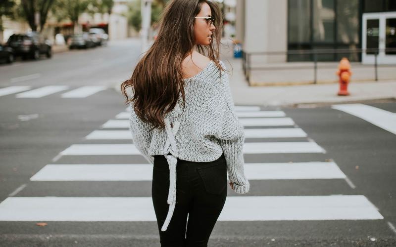 Close to the center of everything a person walking in a crosswalk