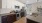 a kitchen with white cabinets brown cabinets a stovetop and a sink and a fridge