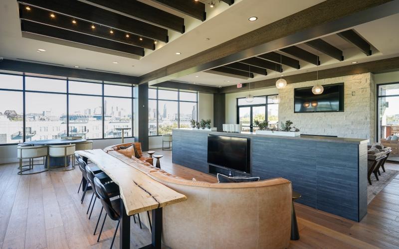 a lounge room with a bar and chairs