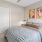 a bedroom with a bed and a fan and side table